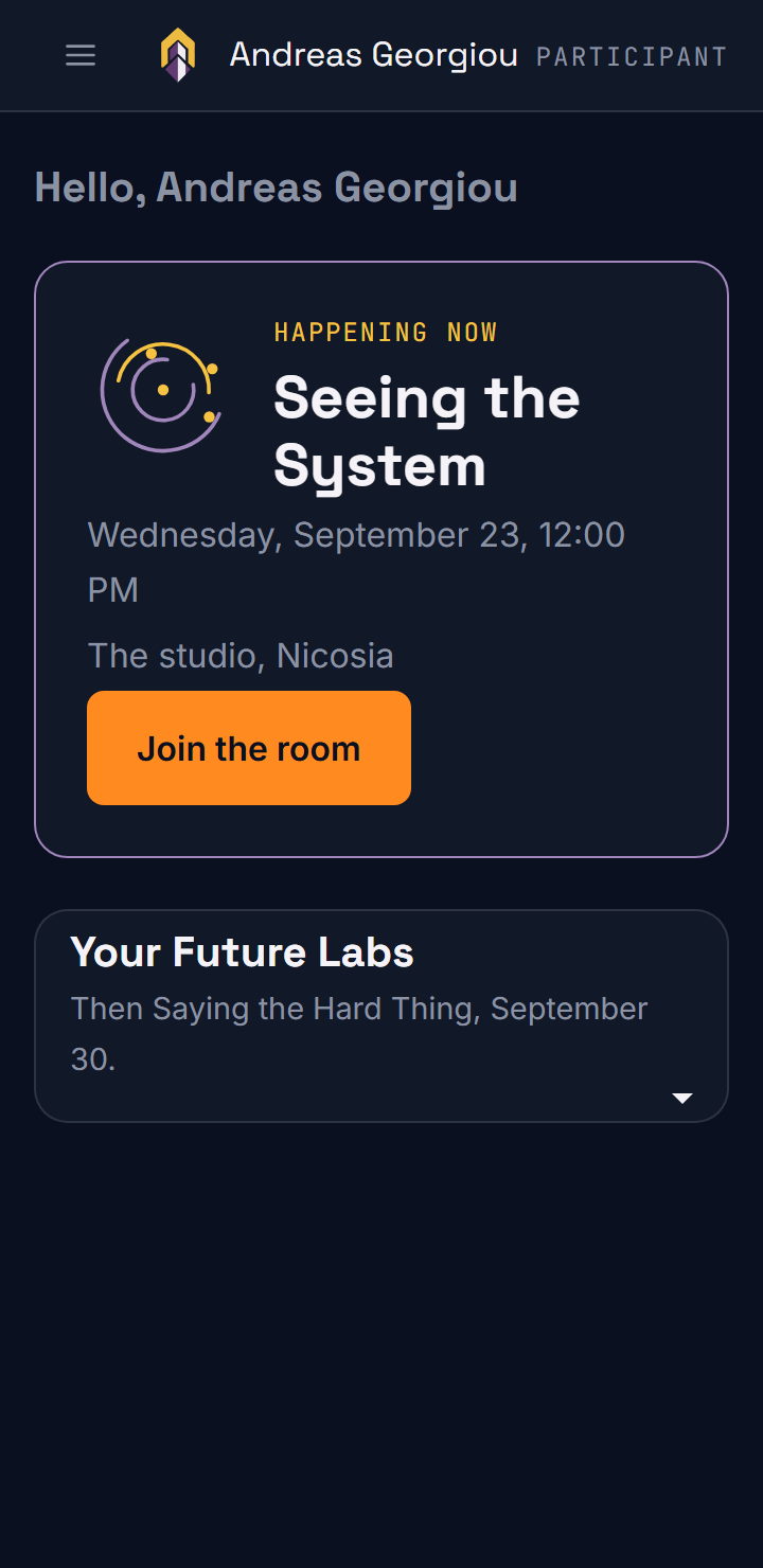 A phone screen that says Hello, Andreas Georgiou. One card reads Happening now: Seeing the System, Wednesday, September 23 at 12:00 PM, the studio, Nicosia, with a Join the room button.